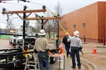 Oncor linemen teach students about the dangers of tree limbs and other objects near power lines in live safety demonstrations.