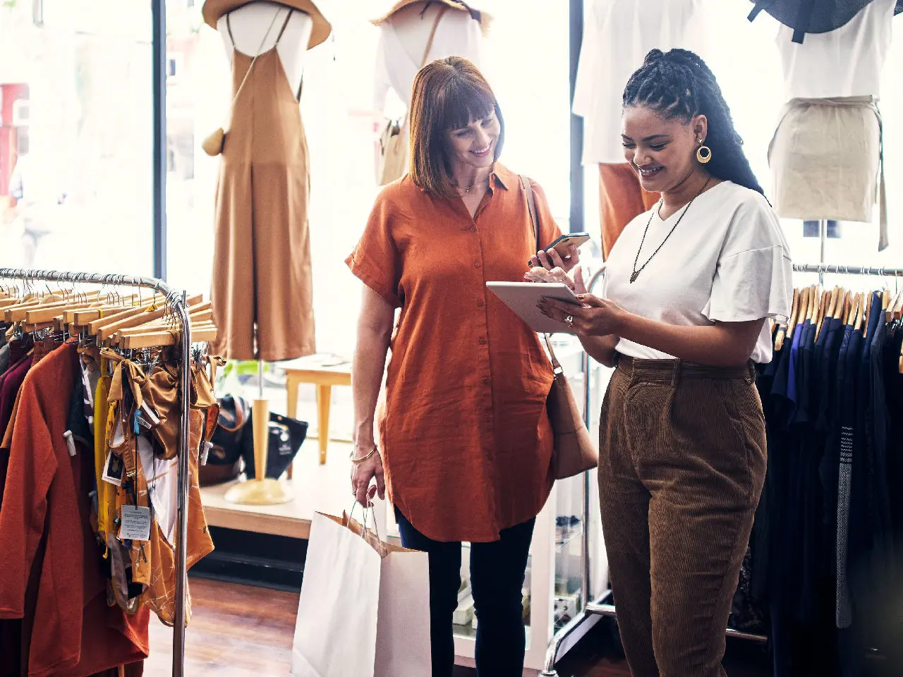 Two women talking inside a clothing store.