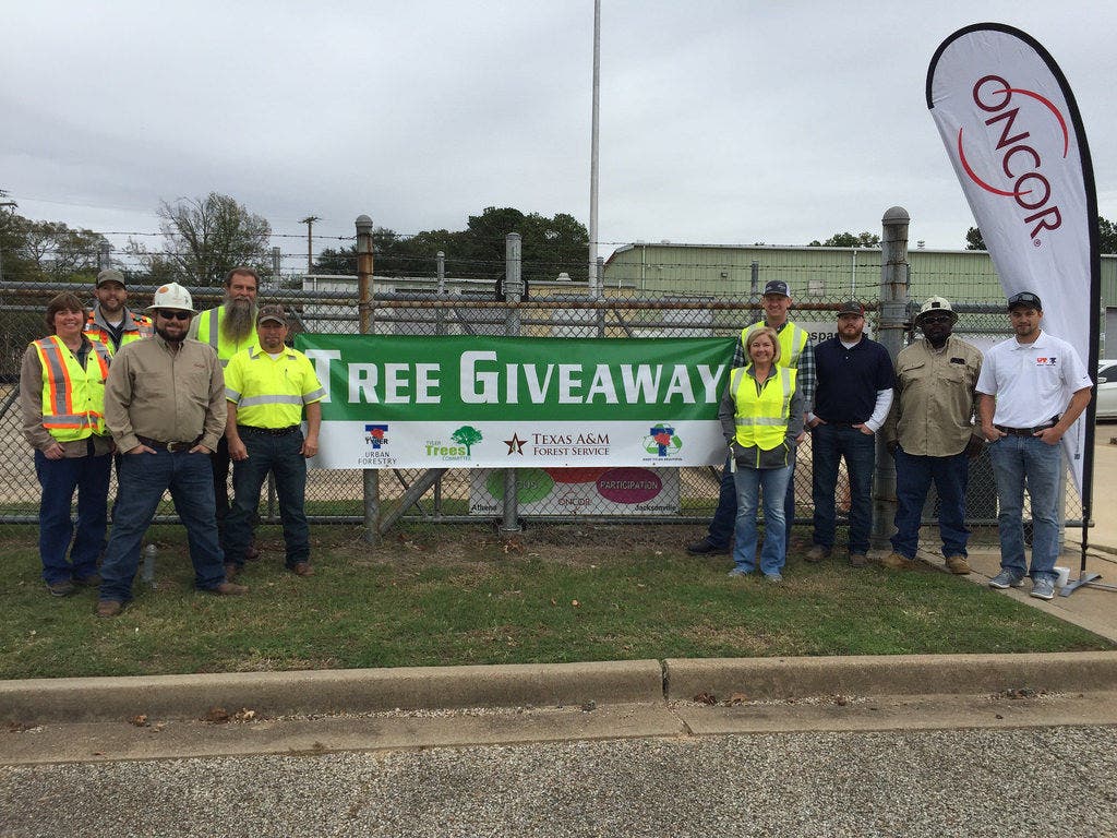 Oncor employees pose for picture at tree giveaway 