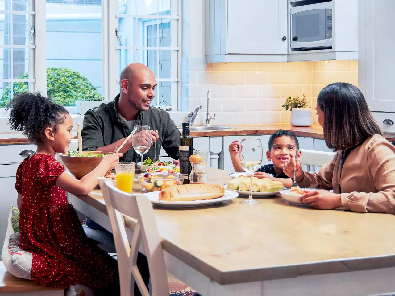 A family eating a meal at the dinner table.