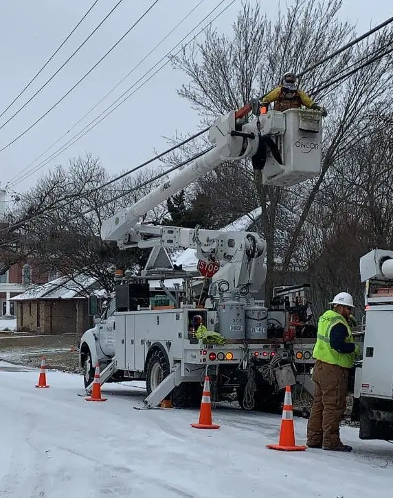 Line workers in bucket truck making repairs 