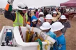 Kids eagerly crowd around an Oncor bucket truck for a close-up look during a live 'Touch a Truck' safety presentation.